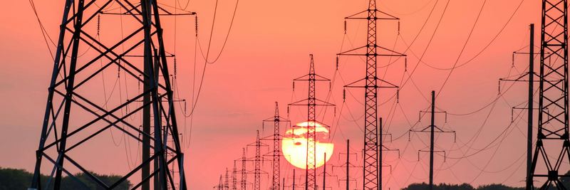 Transmission towers at sunset — utility bill audit services